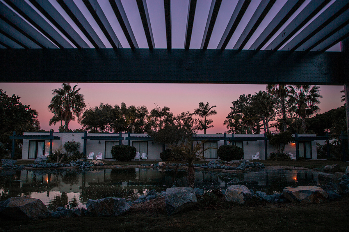 Sunset view of lagoon-front bungalow rooms with palm trees and peaceful water reflections at Paradise Point Resort & Spa in San Diego.