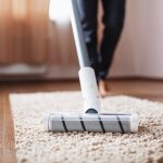 cordless-vacuum-cleaner-cleans-carpet-living-room-with-bottom-legs-modern-technologies-cleaning-house_94046-8292.jpg