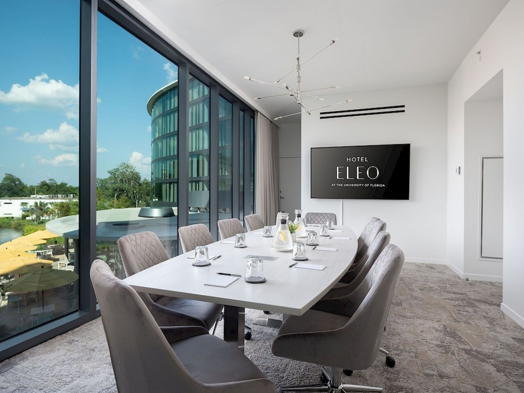 Conference room at Hotel ELEO in Gainesville, Florida with modern decor, large windows, and meeting setup near the University of Florida.
