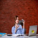 front-view-travel-agent-sitting-her-working-place-holding-toy-plane-agency-service-world-operator-assistant-map-global-ticket-managers.jpeg
